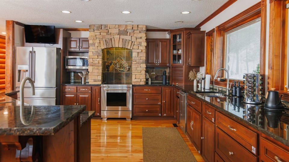 Chef-style kitchen with stainless appliances, stone range surround, and generous counters makes group cooking feel easy