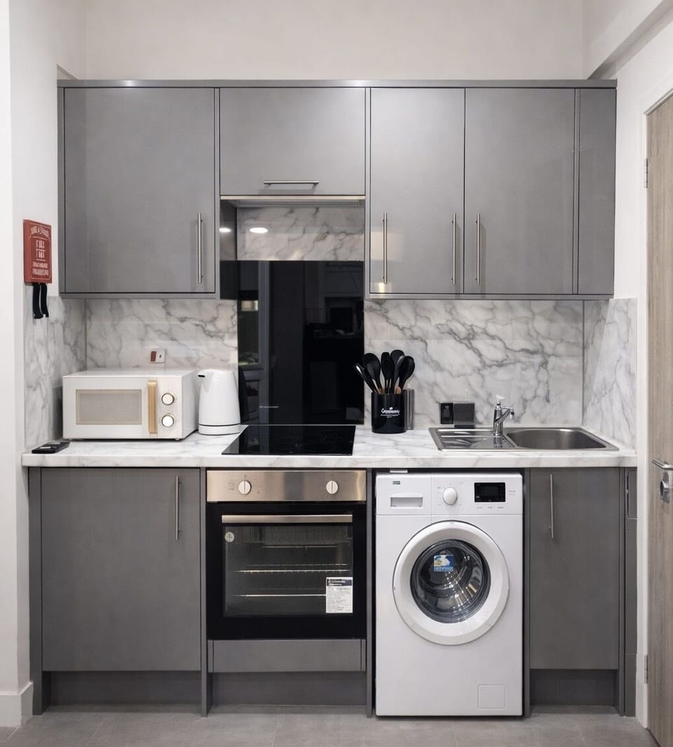 The kitchen is fully equipped with essential items including pans, pots, microwave, toaster, knives, and complimentary basic ingredients like salt, oil, pepper, and vinegar.