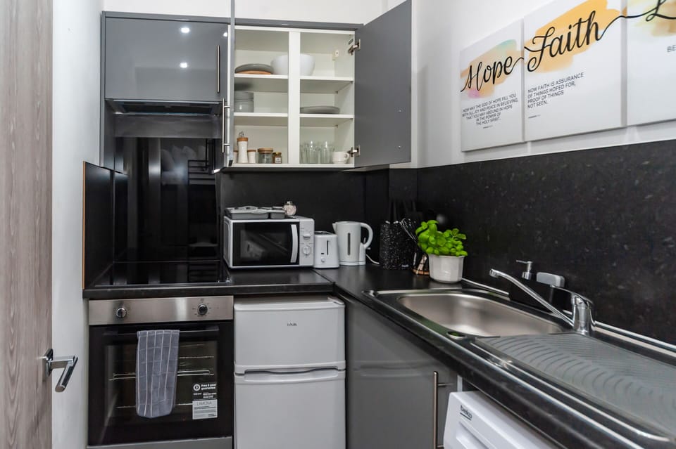 The kitchen is fully equipped with all utensils and appliances, including a mini oven, fridge, and washing machine with complimentary laundry detergent. Everything you need for a comfortable stay.