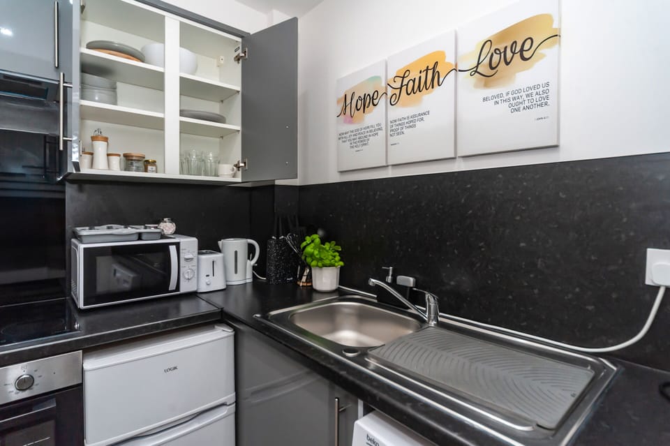 The kitchen is fully equipped with all utensils and appliances, including a mini oven, fridge, and washing machine with complimentary laundry detergent. Everything you need for a comfortable stay.