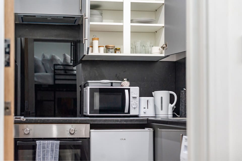 The kitchen is fully equipped with all utensils and appliances, including a mini oven, fridge, and washing machine with complimentary laundry detergent. Everything you need for a comfortable stay.