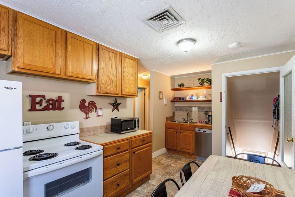 Your fully equipped kitchenette awaits with warm wood cabinets, modern appliances, and charming country touches that make cooking feel like home.