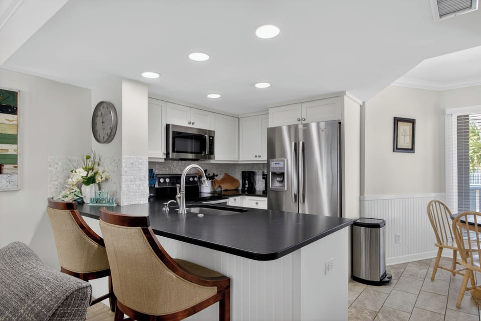 Step into your fully-equipped kitchen with sleek countertops, modern appliances, and a breakfast bar perfect for morning coffee or casual meals together.