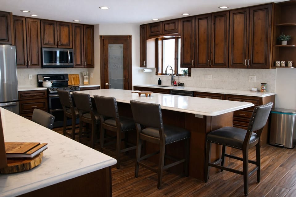 Spacious fully stocked kitchen with large island and seating for gathering.