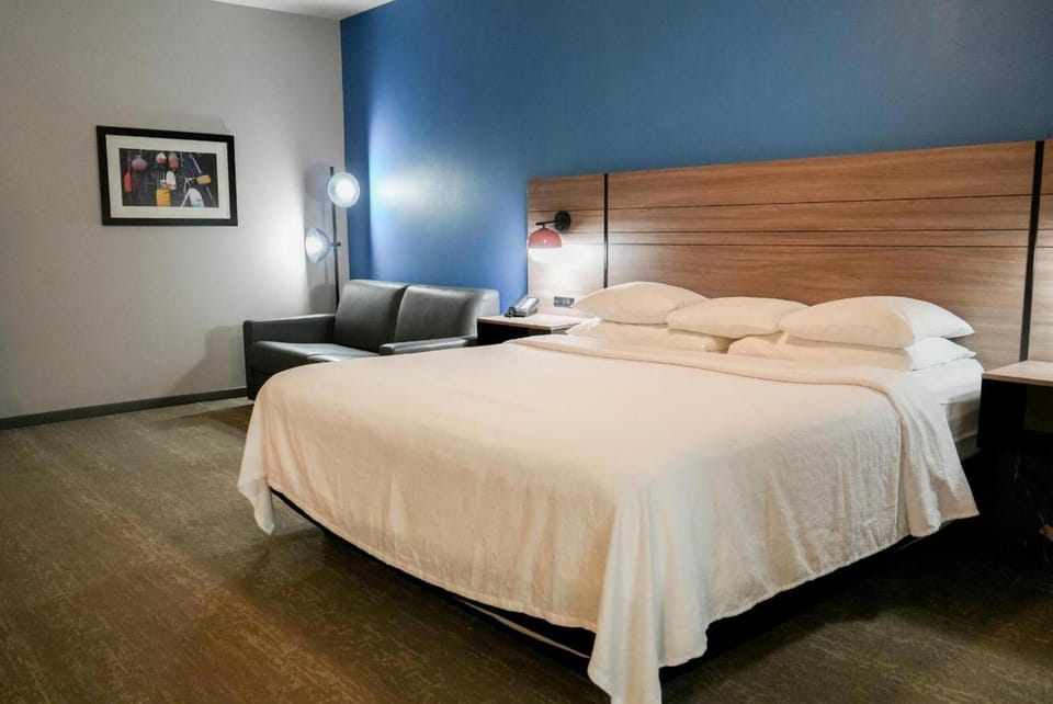 Relax on plush seating beside a sleek, inviting king bed.