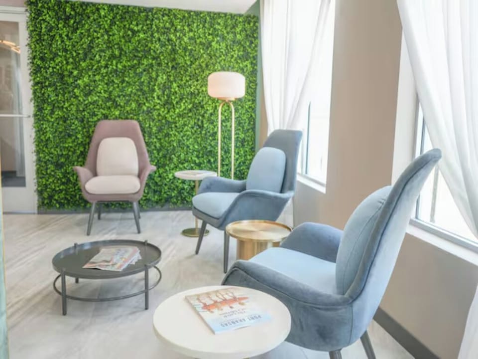 Unwind in plush lounge chairs beside a soothing green wall.