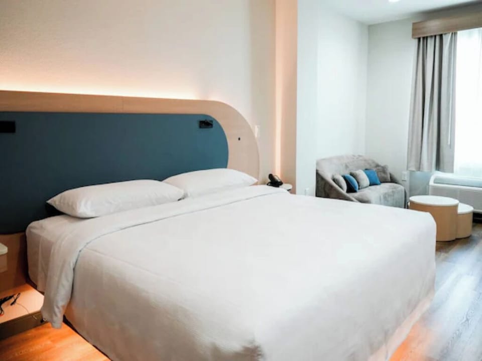 Unwind in a cloud-soft king bed beside a cozy lounge.