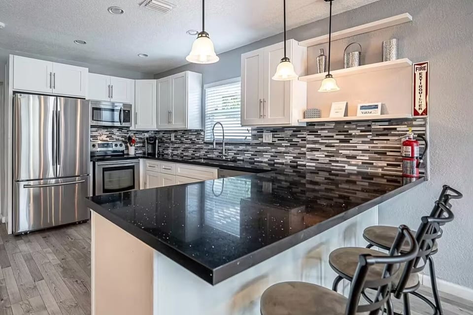 Modern kitchen with stainless steel appliances, large island, and bar seating for casual dining and entertaining.