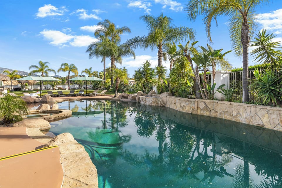 Resort-style pool framed by swaying palms, lush landscaping, and plenty of space to lounge in the Temecula sun.