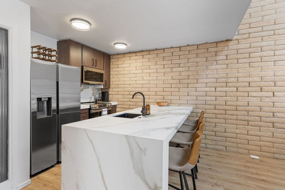 Fully equipped kitchen with stainless steel appliances and marble countertops