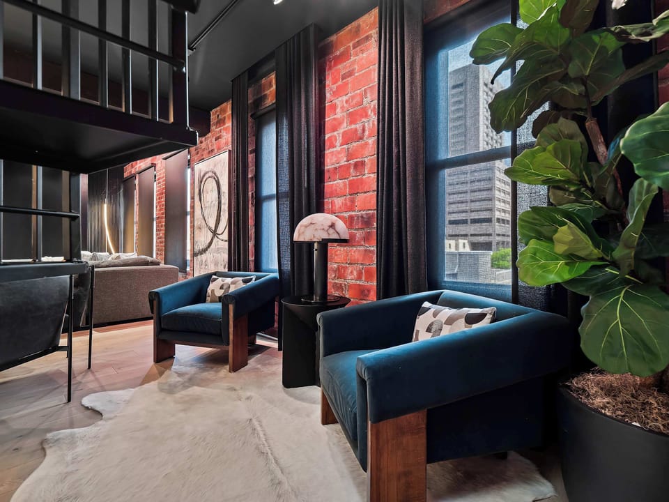 Lounge space w/ velvet seating, brick accents & moody lighting