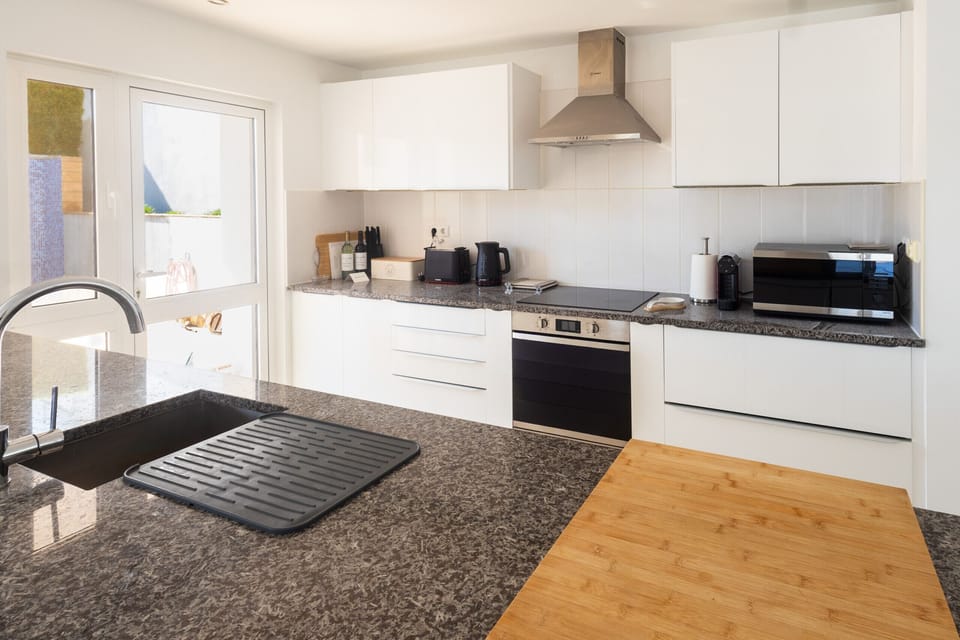 Modern, white kitchen with marble tops and Bosch appliances