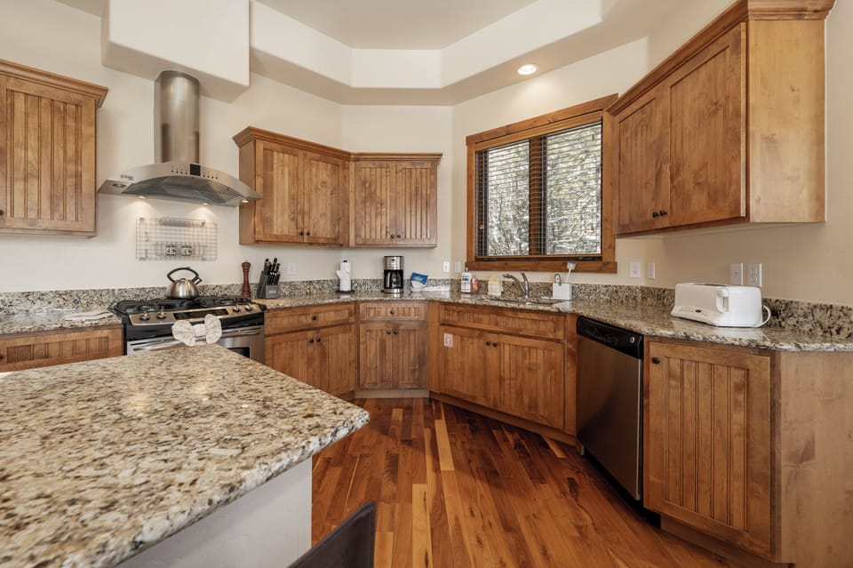 Your gourmet kitchen awaits with granite counters, rich wood cabinets, and modern appliances for creating memorable meals together.