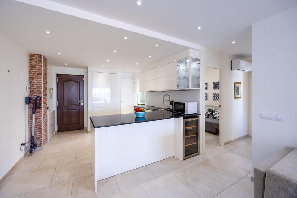 Modern kitchen with sleek black countertops and built-in wine cooler.