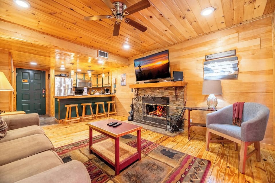 Cozy up in your rustic retreat with warm wood walls, a crackling fireplace, and modern comforts creating the perfect mountain getaway atmosphere.