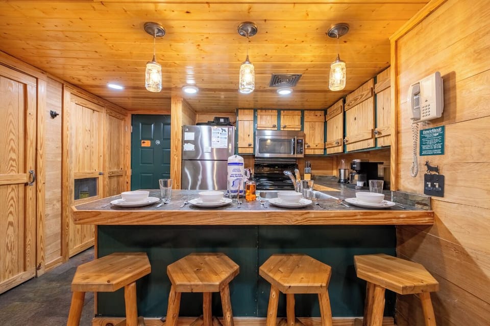 Your cozy cabin kitchen awaits, complete with rustic wood charm and modern appliances for memorable meal prep together.