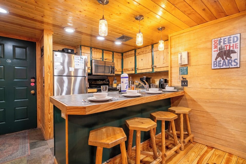 Your cabin kitchen blends rustic charm with modern convenience, featuring warm wood finishes and everything you need for memorable meals.