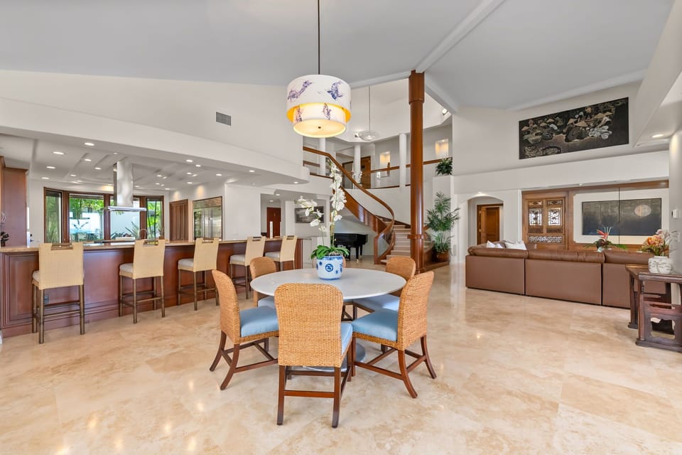 Gather beneath soaring ceilings where open living spaces flow effortlessly from dining to lounge areas.