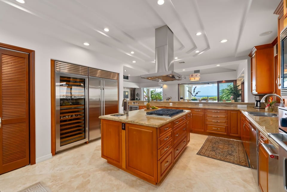 Rich cabinetry, oversized islands, and soft natural light create a welcoming space for cooking and connection.