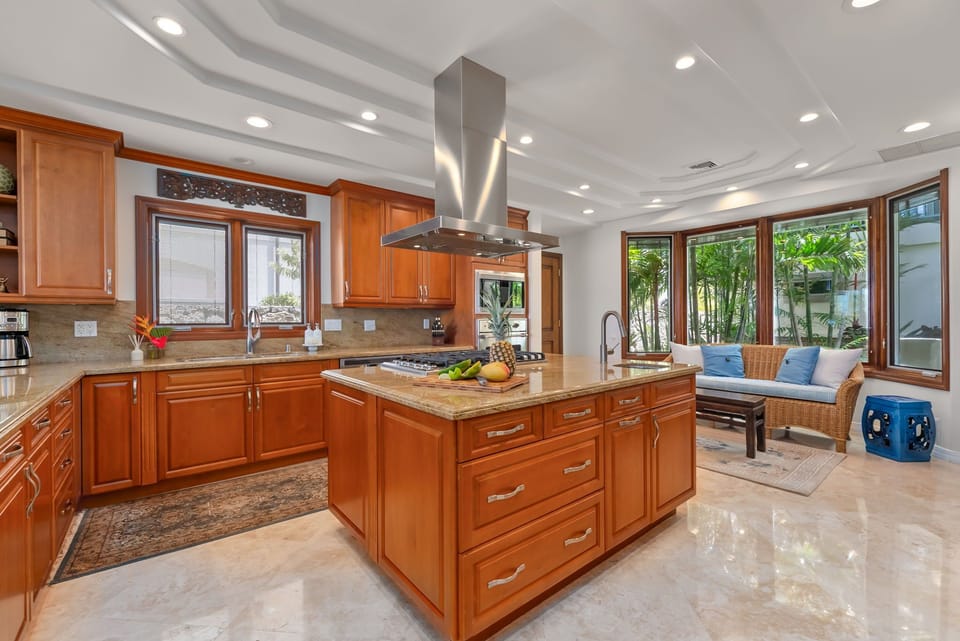 The chef's kitchen pairs generous prep space with tropical views and seamless indoor comfort.