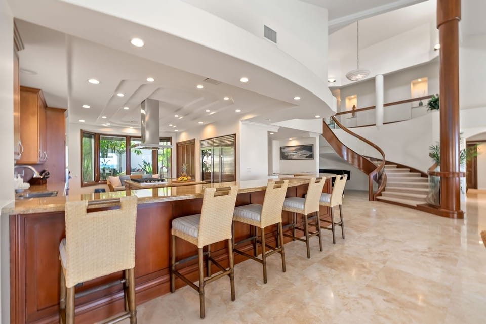 A striking spiral staircase anchors this bright interior designed for relaxed gatherings and easy conversation.