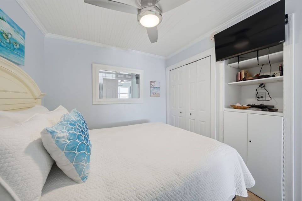 Queen bedroom with mounted flat-screen TV