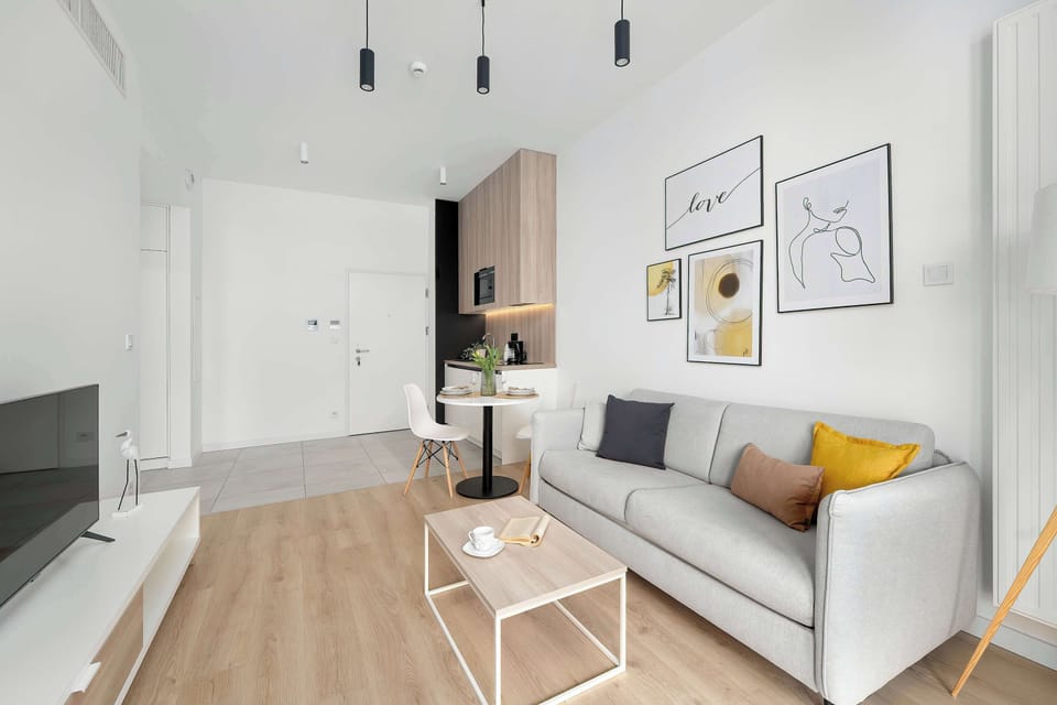 A combined living and dining space with a sofa, round table, and chairs. The layout is open and functional, ideal for relaxing or enjoying meals.