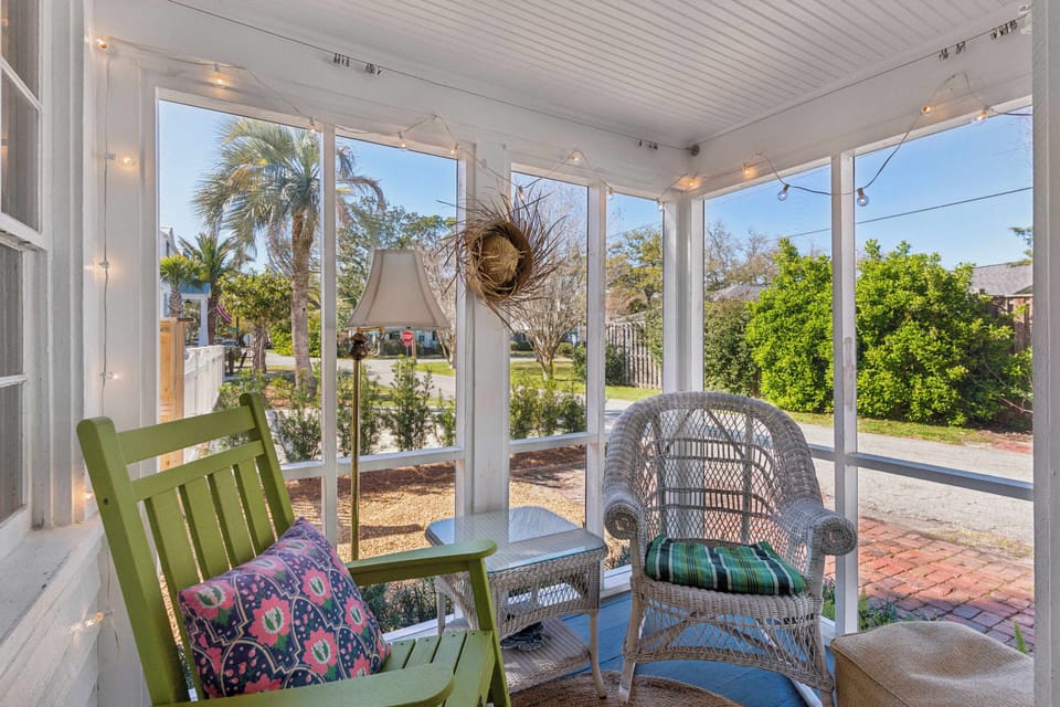 Your screened porch offers the perfect retreat with cozy wicker seating and twinkling string lights for magical evening moments.