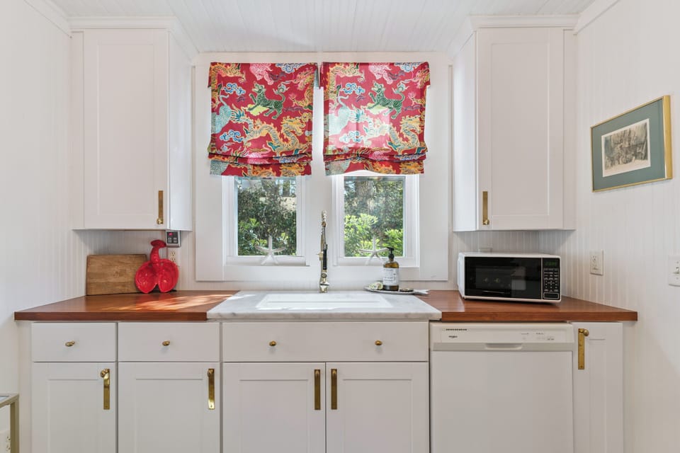 Your bright kitchen features warm wood counters, cheerful floral curtains, and everything needed for easy meal prep during your stay.