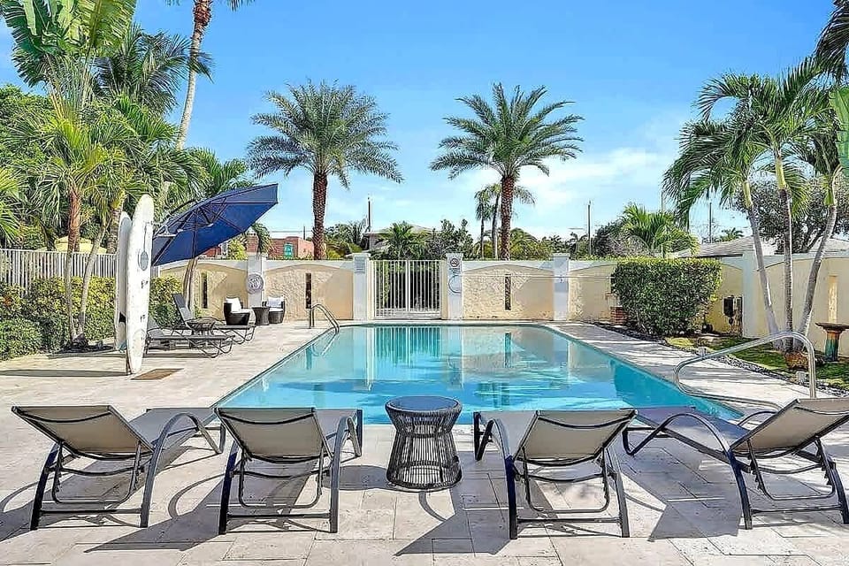 Sparkling shared pool with lounge chairs and palms