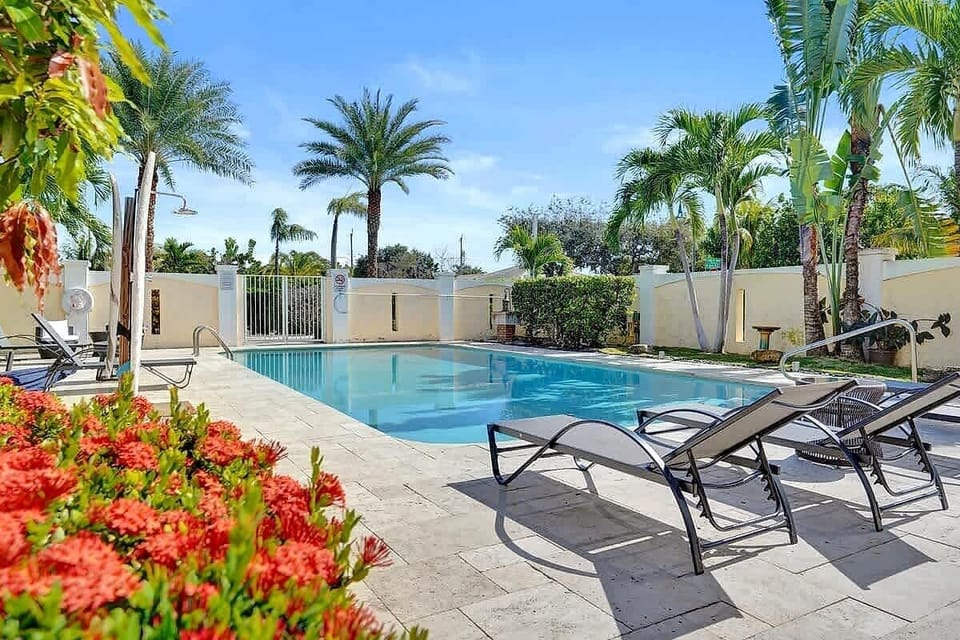Sparkling pool with tropical palms and lounge chairs