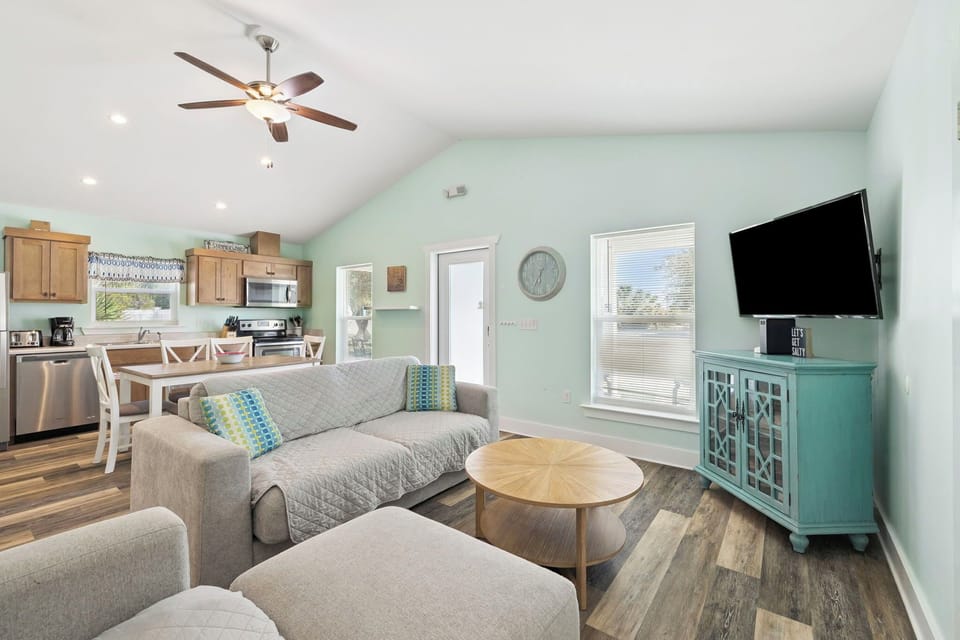 Relax in your bright, open-concept living space with cozy seating, modern kitchen, and soothing coastal colors.