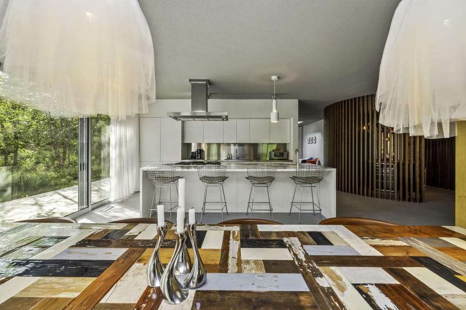 Sunlit kitchen and dining with sleek island and large windows