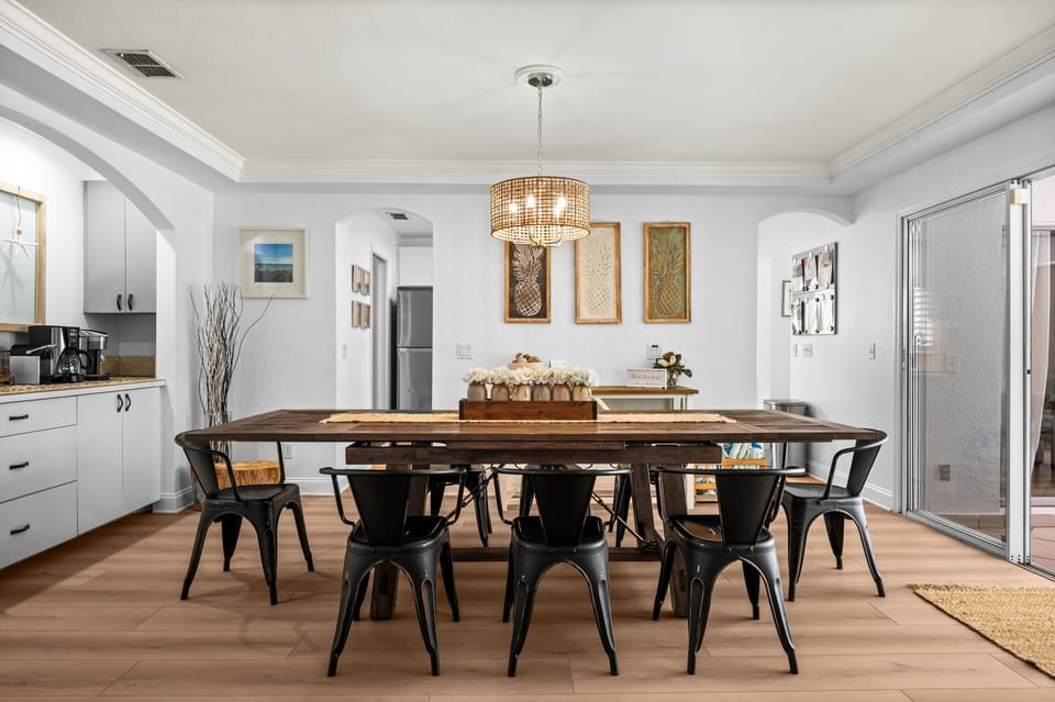 A stylish dining room with a large table perfect for gathering - ideal for shared meals, conversation, and making memories together during your stay.