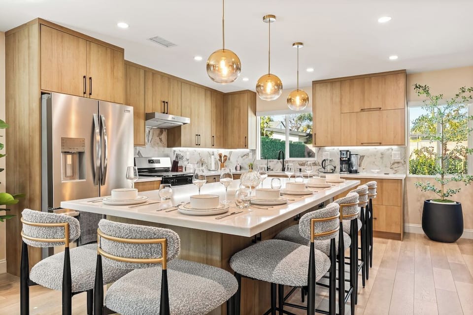 Fully equipped open-concept kitchen featuring modern appliances, cookware, and dining essentials.