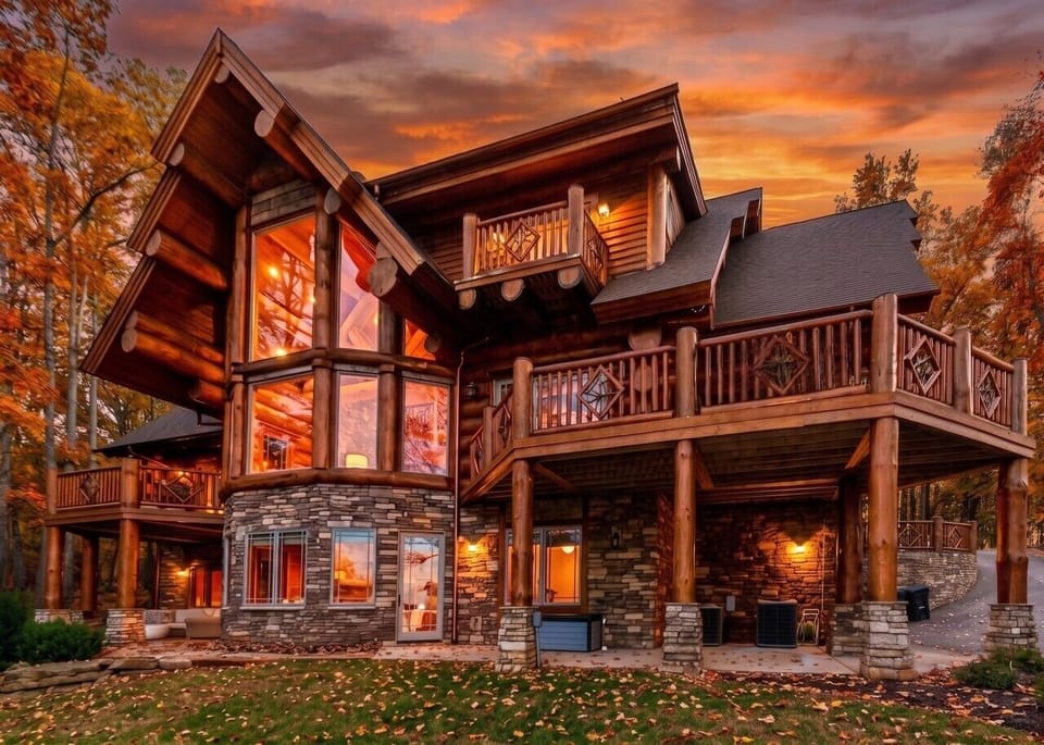 Multiple decks and gathering spaces make this luxury log cabin ideal for groups, offering privacy, comfort, and beautiful views from every level as the home glows in the evening light.