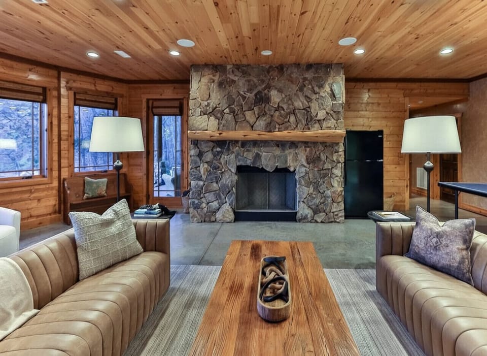 This comfortable lower-level living room offers soft lighting, and ample seating—creating a relaxed retreat for downtime, games, or movie nights.