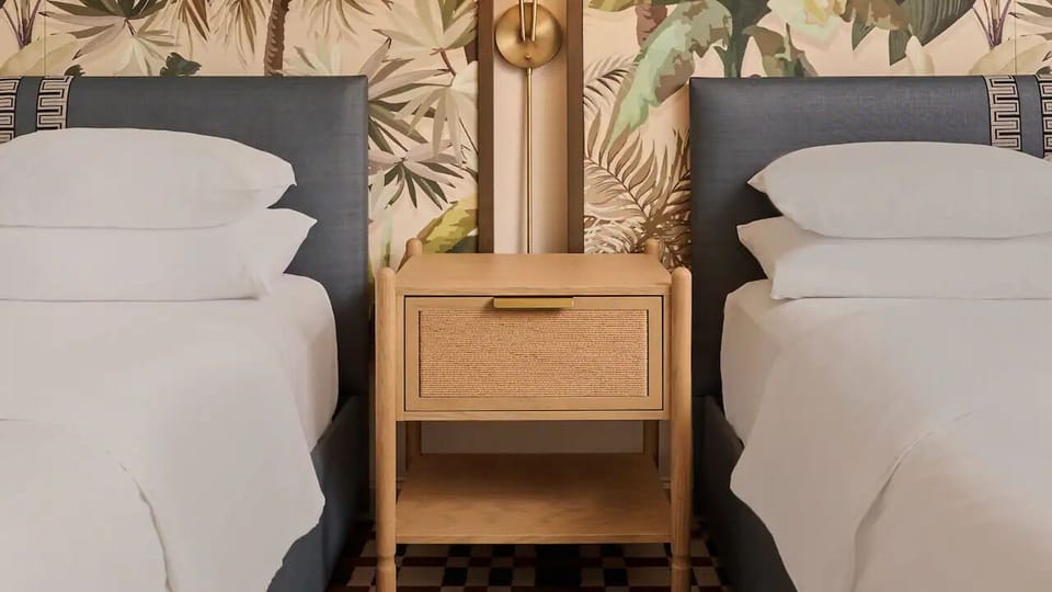 Drift off between crisp linens and tropical-inspired headboard design.