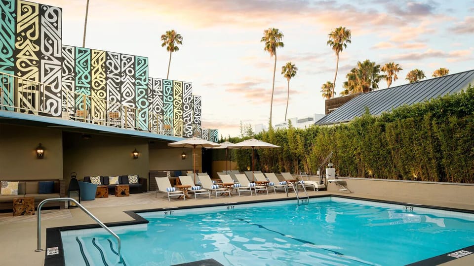 Unwind at sunset with palms, loungers, and shimmering water.