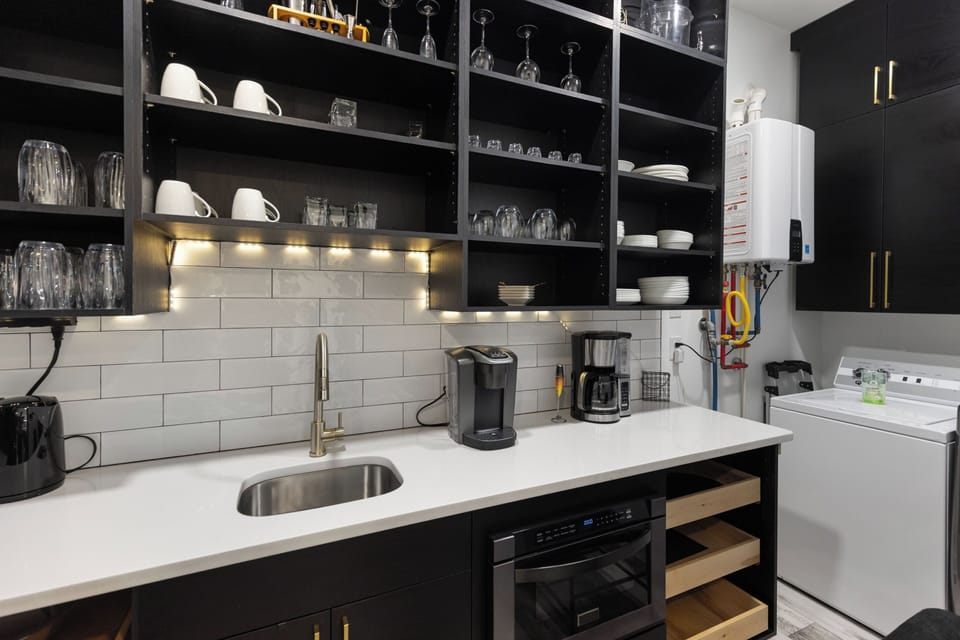 Your sleek modern kitchen awaits with premium appliances, open shelving, and everything you need for memorable meals.