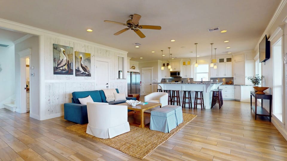 Spacious great room with multiple seating areas and wood flooring in this modern Crystal Beach Texas vacation rental.