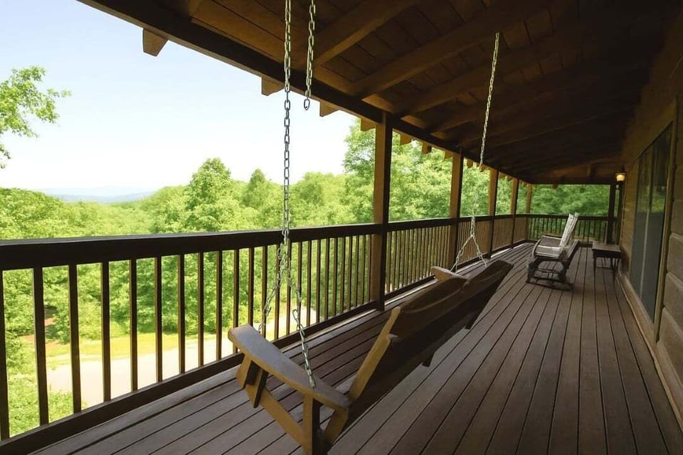 Spacious covered deck with porch swing and stunning mountain views at Mountain Paradise log cabin in Wears Valley, Tennessee — perfect for morning coffee or evening relaxation