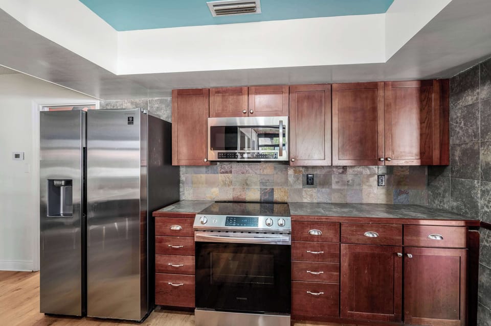 Modern kitchen with stainless steel appliances and rich wood cabinetry