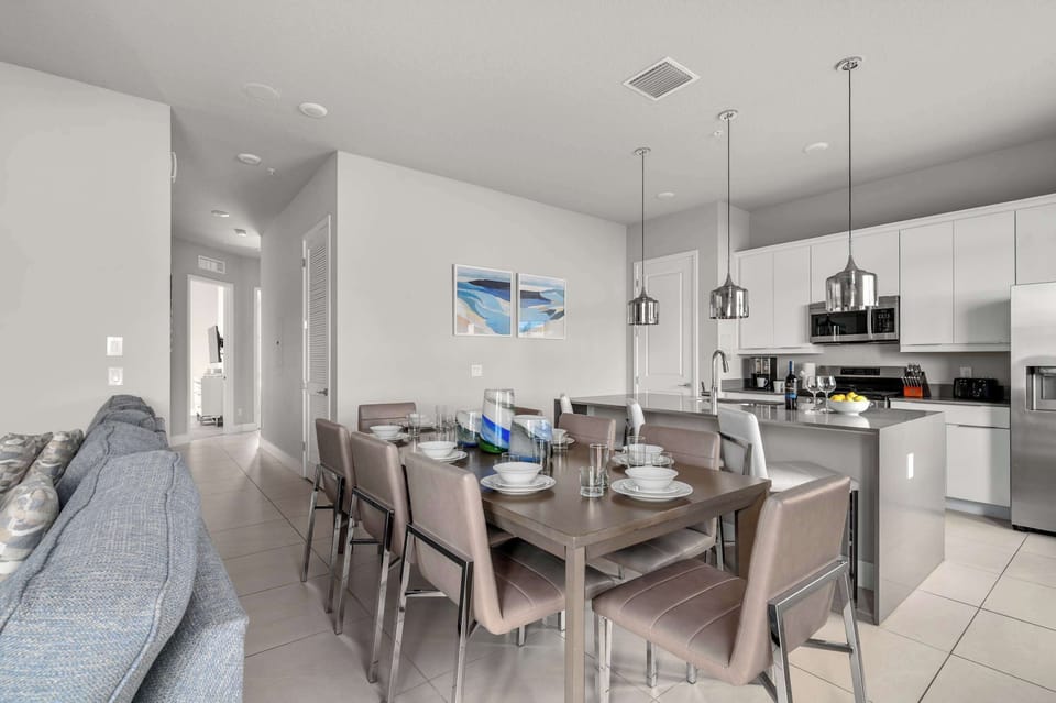 Modern kitchen and dining area with seating for eight and stainless steel appliances