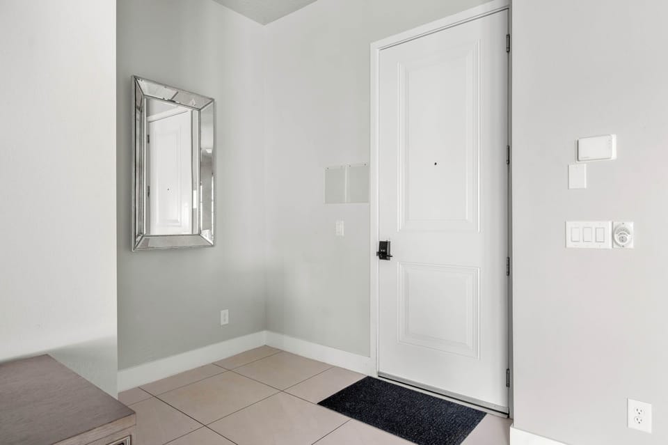 Entryway with a full-length mirror and tiled flooring for convenience.