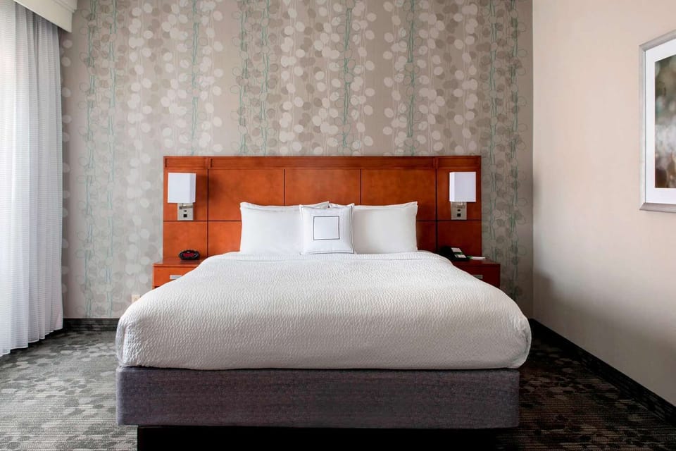 Unwind in a crisp king bed with soft, quiet comfort.