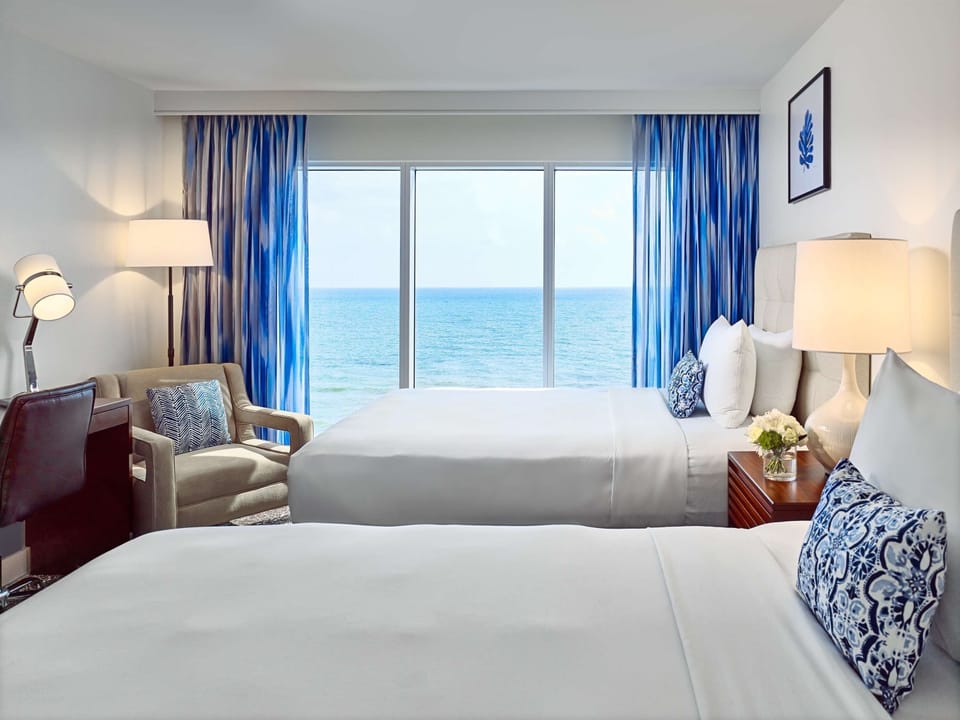 Settle into crisp beds while the ocean fills the window.
