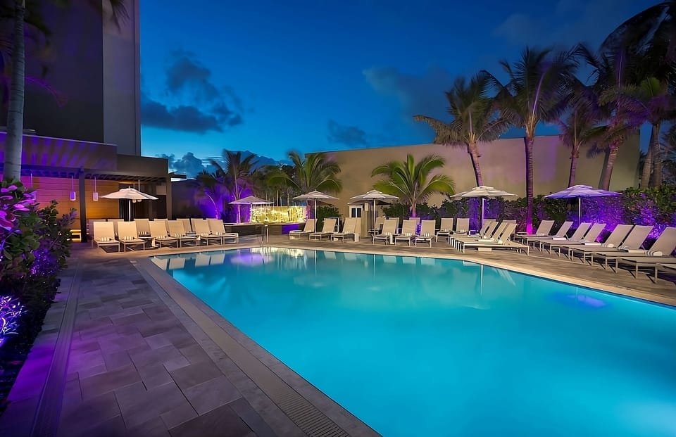 Dive into a glowing twilight pool surrounded by palms.