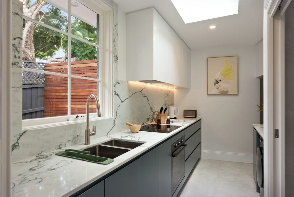 Cook with a view! This sleek, fully-equipped kitchen features premium finishes and a serene leafy outlook.