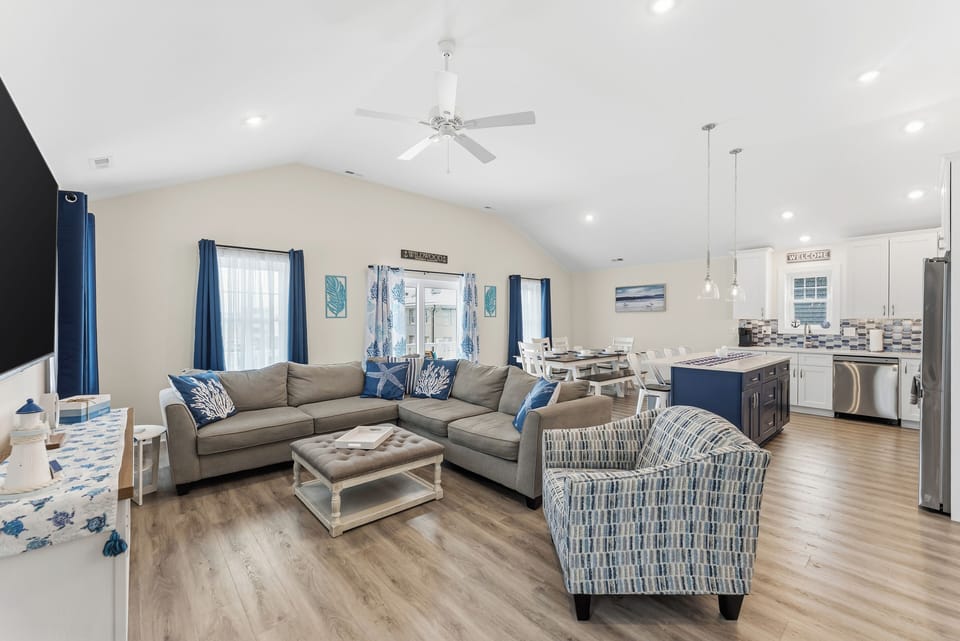 Bright coastal-style great room with open kitchen, dining, and spacious seating